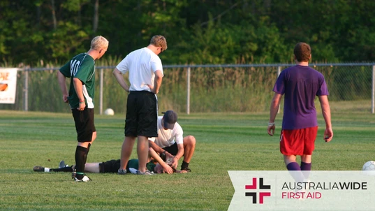 A soccer player lying on the floor with a head injury